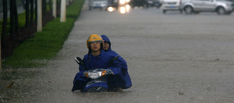 Two men on a motorcycle are stuck in floodwaters in Wuhan in central China's Hubei province Saturday June 18, 2011. Flooding from this month's seasonal rains has already forced hundreds of thousands of people from their homes and left more than 170 dead or missing. (AP Photo) CHINA OUT