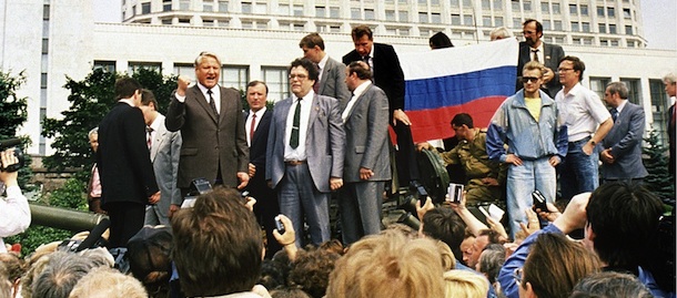 Russian President Boris Yeltsin (L), shown in picture dated 19 August 1991 in Moscow, stands on top of an armoured vehicle parked in front of the Russian Federation building as supporters hold a Russian federation flag. Yeltsin addressed a crowd of supporters calling for a general strike following a military coup against Soviet President Gorbachev. (Photo credit should read DIANE-LU HOVASSE/AFP/Getty Images)