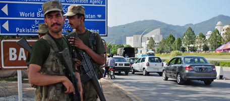 Pakistani soldiers stand beside a check point near the parliament house in Islamabad on May 13, 2011, during the joint sitting of parliament where Pakistan's intelligence chief Ahmad Shuja Pasha and army chief of staff Ashfaq Kayani briefed lawmakers on the bin Laden operation. Pakistan's Taliban on May 13 claimed their first major attack to avenge Osama bin Laden's death as 80 people were killed in a double suicide bombing on a paramilitary police training centre. AFP PHOTO/Farooq NAEEM (Photo credit should read FAROOQ NAEEM/AFP/Getty Images)