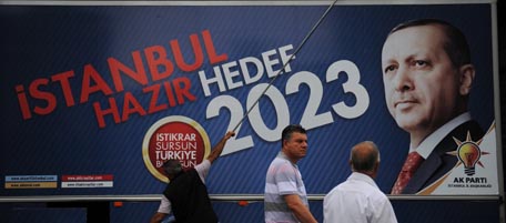 Turkish people walk past Turkish Prime Minister Tayyip Erdogan's election campaign poster in Istanbul on June 11, 2011. Turkey will hold parliamentary elections on June 12. AFP PHOTO/BULENT KILIC (Photo credit should read BULENT KILIC/AFP/Getty Images)