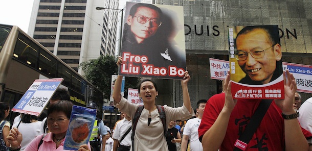Pro-democracy protesters hold the picture of Chinese dissident Liu Xiaobo and written 'Release Liu Xiaobo' as they march to the China's Liaison Office in Hong Kong Sunday, Oct. 10, 2010. Awarding the Nobel Peace Prize to an imprisoned Chinese dissident sparked praise from Western governments, brought condemnation from Beijing and is exposing the difficulties fitting a powerful, authoritarian China into the international order. A day after Liu Xiaobo was named the winner, a touchy Chinese government built upon its initially angry response Saturday. (AP Photo/Kin Cheung)