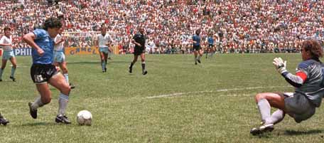Argentinian forward Diego Armando Maradona runs past English defender Terry Butcher (L) on his way to dribbling goalkeeper Peter Shilton (R) and scoring his second goal during the World Cup quarterfinal soccer match between Argentina and England 22 June 1986 in Mexico City. Argentina advanced to the semifinals with a 2-1 victory. AFP PHOTO (Photo credit should read STAFF/AFP/Getty Images)