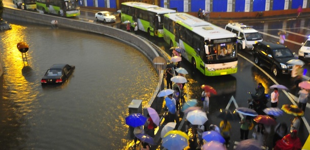 This photo taken on June 23, 2011 shows pedestirans stranded on a flyover after rainstorms which flooded a large part of the city of Beijing. China, already hit by torrential downpours that have left more than 260 dead or missing, braced Tuesday for more rains and wind as a tropical storm neared its southern coast, weather authorities said. CHINA OUT AFP PHOTO (Photo credit should read STR/AFP/Getty Images)