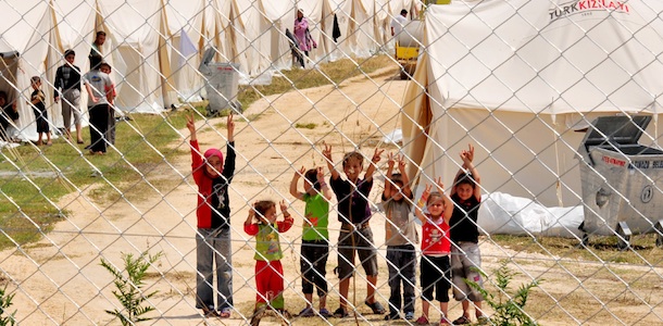 Syrian refugee children flash V-signs at the Boynuyogun Turkish Red Crescent camp in the Altinozu district of Hatay, near the Syrian border, on June 12, 2011. Some 400 Syrian refugees crossed into Turkey overnight, bringing to more than 5,000 the number of people to have fled the security crackdown in Syria, the Anatolia news agency reported on June 11. AFP PHOTO / MUSTAFA OZER (Photo credit should read MUSTAFA OZER/AFP/Getty Images)