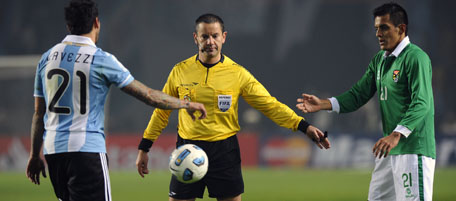 Uruguayan referee Roberto Silvera stands next to Argentine forward Ezequiel Lavezzi (L) and Bolivian midfielder Jhasmani Campos during a 2011 Copa America Group A first round football match held at the Ciudad de La Plata stadium in La Plata, 59 Km south of Buenos Aires, on July 1, 2011. The match ended tied 1-1. AFP PHOTO / DANIEL GARCIA (Photo credit should read DANIEL GARCIA/AFP/Getty Images)