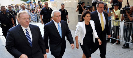 Former IMF head Dominique Strauss-Kahn (C) and his wife Anne Sinclair arrive for a hearing at New York State Supreme Court July 1, 2011 in New York. Strauss-Kahn is awaiting trial on sex-assault charges. Prosecutors have agreed to free former IMF chief Dominique Strauss-Kahn from house arrest and return his bail money after admitting major problems with his accuser's credibility, a report said Friday. If the judge agrees, Strauss-Kahn would be freed "on his own recognizance," meaning he could travel freely in the United States and have his $1 million bail and $5 million bond returned, Bloomberg TV reported, citing two sources familiar with the case. AFP PHOTO/Stan HONDA (Photo credit should read STAN HONDA/AFP/Getty Images)