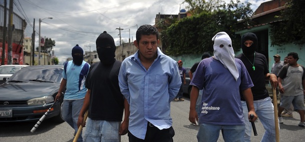 Hooded men detain a man, suspected to belong to the Salvatrucha gang, in Castanas neighborhood, in the southern outskirts of Guatemala City on July 19, 2011. The residents of Castanas have been threatened and extorted by members of the Salvatrucha gang, and as a way to defend themselves, they decided to organize their own armed gang. AFP PHOTO / Johan ORDONEZ (Photo credit should read JOHAN ORDONEZ/AFP/Getty Images)