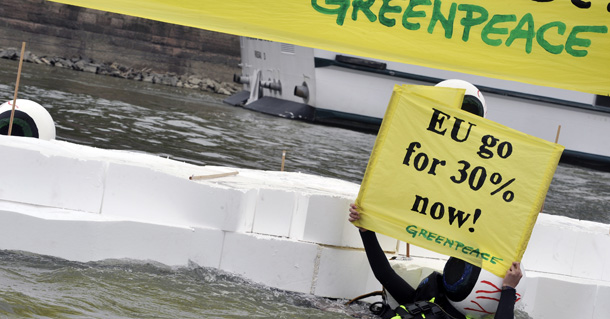 A Greenpeace activist holds a banner, reading: "EU Go to 30 Percent Now!" next to a platform representing ice on the Danube river in the center of Budapest on June 29, 2011. Greenpeace was demonstrating for a 30 percent reduction of the greenhouse gas emissions as Hungary ends its six months rotating EU presidency on June 30. AFP PHOTO / ATTILA KISBENEDEK (Photo credit should read ATTILA KISBENEDEK/AFP/Getty Images)