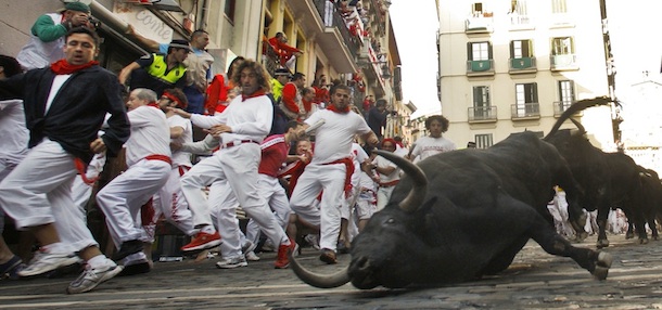 Revelers run on the Estafeta corner as one Jose Cebada Gago ranch falls during the second running of the bulls at the San Fermin fiestas in Pamplona northern Spain, Friday July 8, 2011. (AP Photo/Alvaro Barrientos)