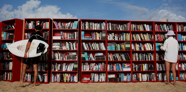 SYDNEY, AUSTRALIA - JANUARY 31: Beach goers select books from 30 red Ikea Billy bookcases lined up to form the world's longest outdoor bookcase to celebrate the 30th birthday of the brand's signature furniture piece, at Bondi Beach on January 31, 2010 in Sydney, Australia. The bookcases were filled with thousands of books which beachgoers can swap for one of their own or make a gold coin donation to buy, with proceeds to The Australian Literacy &amp; Numeracy Foundation. (Photo by Lisa Maree Williams/Getty Images)