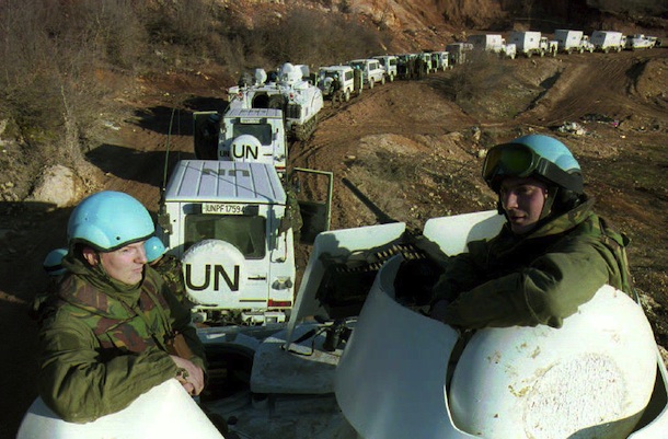 LUKAVAC, BOSNIA AND HERZEGOVINA: Two Dutch soldiers ride on an armored vehicle accompanying a Dutch UN convoy of 56 engineering vehicles on their way to Lukavac 28 February 1994 in Bosnia-Hercegovina. Another Dutch convoy reached the eastern Bosnian town of Srebrenica late 28 February. (Photo credit should read ED OUDENAARDEN/AFP/Getty Images)