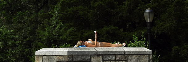 A woman reads a book on top of the staircase at Carl Schurz Park on the Upper east Side of New York City on July 21, 2011 as people try different ways to beat the hot weather. Heat indexes as expected to reach near 105Fdegrees (40.5C) . AFP PHOTO / TIMOTHY A. CLARY (Photo credit should read TIMOTHY A. CLARY/AFP/Getty Images)