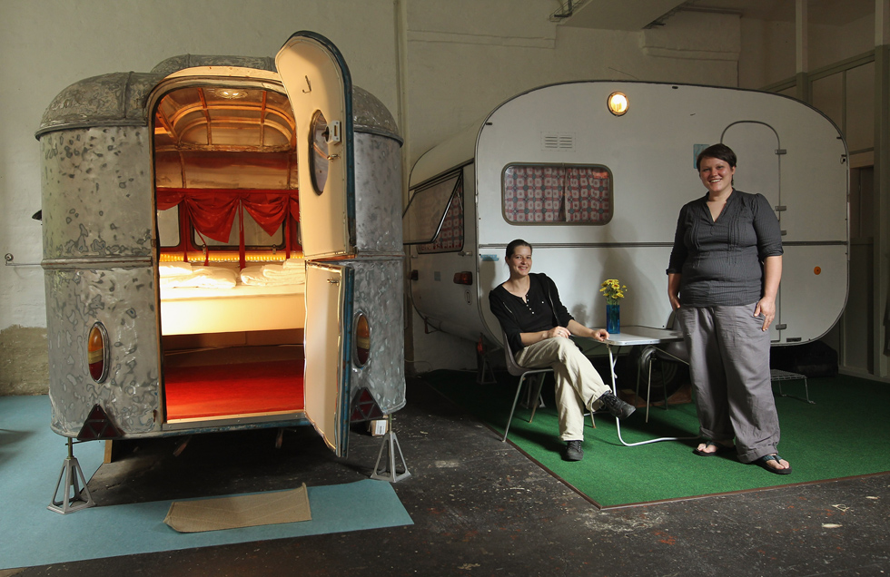 Silke Lorenz e Sarah Vollmer posano accanto a due roulotte che offrono come stanze per i loro ospiti al Huettenpalast Hotel (Sean Gallup/Getty Images)