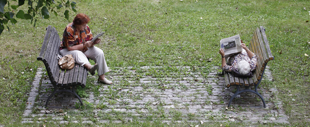 BERLIN, GERMANY - AUGUST 21: Women relax reading newspapers on a bench on a sunny day near the Tiergarten parc on August 21, 2011 in Berlin, Germany. (Photo by Andreas Rentz/Getty Images)