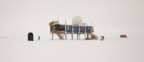 In this July 15, 2011 photo, in freezing temperatures, a researcher walks from an outhouse to the primary facility at Summit Station, a small U.S. National Science Foundation research center situated 10,500 feet above sea level, on top of the Greenland ice sheet. The primary facility is periodically jacked up on its support columns to stay above accumulating snow. Across Greenland's vast white landscape, small teams of researchers from around the world are searching for clues to the potential effects of global warming on Greenland's ice. (AP Photo/Brennan Linsley)