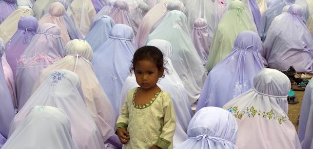 PATTANI,THAILAND - AUGUST 30: A girl stands near her mother as Thai muslim women pray during the special Eid ul-Fitr morning prayer at the Central mosque of Pattani August 30, 2011 in the southern province of Pattani, Thailand. The three-day holiday, Eid ul-Fitr, marks the end of Ramadan, the Islamic month of fasting and begins after the sighting of a new crescent moon. (Photo by Paula Bronstein/Getty Images)
