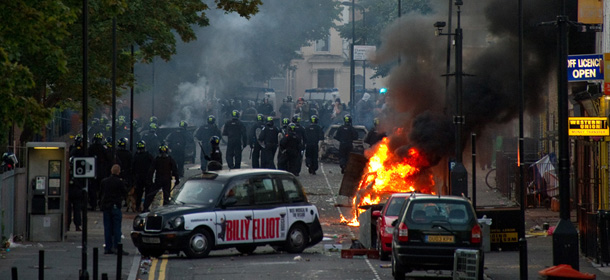 Riot police tackle a mob after a number of cars are set alight in Hackney, north London on August 8, 2011. Riot police faced off with youths in fresh violence in London today in the third day of disorder after some of the worst rioting in the British capital in years at the weekend. The riots broke out in the north London district of Tottenham on August 6, following a protest against the death of a local man in a police shooting last week, and the violence spread to other parts of the city on August 7. AFP PHOTO/LEON NEAL (Photo credit should read LEON NEAL/AFP/Getty Images)