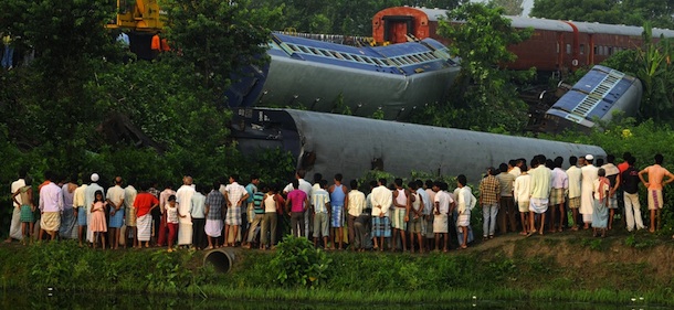 Bystanders watch as rescue workers attend to the scene of a train crash in Bagharpur near Malda, some 350 kms from Kolkata on August 1,2011. At least one fatality and several injured were being reported following the collision of the Bangalore-Guwahati express train which derailed in the incident which happened overnight. AFP PHOTO / Diptendu DUTTA (Photo credit should read DIPTENDU DUTTA/AFP/Getty Images)