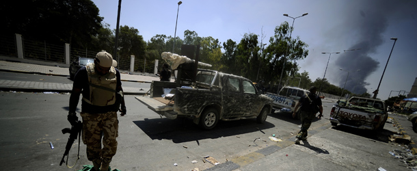 A rebel steps on the green Libyan flag laying on a street of the capital Tripoli on August 25, 2011, as rebel forces root out the last vestiges of fighters loyal to Libyan leader Moamer Kadhafi. AFP PHOTO / Filippo MONTEFORTE (Photo credit should read FILIPPO MONTEFORTE/AFP/Getty Images)