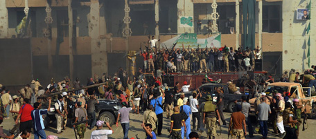 Rebels and their supporters celebrate outside Libyan leader Moamer Kadhafi's heavily damaged Bab al-Azizya compound in the centre of Tripoli on August 24, 2011, as explosions and gunfire rocked the streets of the Libyan capital before and after dawn, reminding fearful residents that Kadhafi's forces still pose a threat despite being routed by rebels. AFP PHOTO/FILIPPO MONTEFORTE (Photo credit should read FILIPPO MONTEFORTE/AFP/Getty Images)