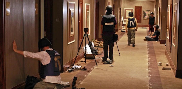 Journalists work in a hallway as gun-battles continue around the Rixos hotel in Tripoli, Libya, Tuesday, Aug. 23, 2011. Dozens of journalists remain trapped inside this hotel as forces loyal to Moammar Gadhafi prevent them from leaving and gun battles with rebel forces continue all around. (AP Photo/Dario Lopez-Mills)