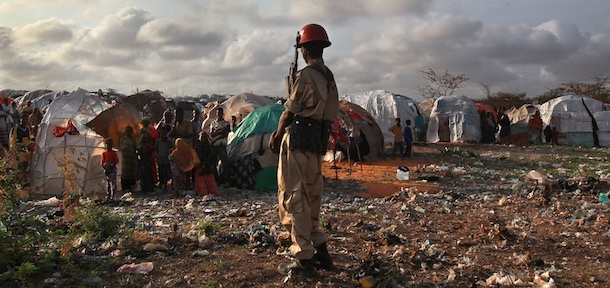 MOGADISHU, SOMALIA - AUGUST 19: A Somali soldier looks onto a camp for people displaced by famine and drought on August 19, 2011 in Mogadishu, Somalia. The UN says that more than 100,000 people have migrated to Mogadishu in the last few months to escape the drought crisis in the countryside. (Photo by John Moore/Getty Images)