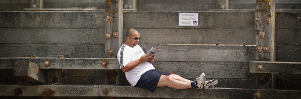 WHITSTABLE, UNITED KINGDOM - AUGUST 03: A man sits on a beach groyne reading a book on August 3, 2011 in Whitstable, England. Parts of southern England are experiencing high summer temperatures. (Photo by Peter Macdiarmid/Getty Images)