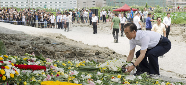 In this photo released by China's Xinhua news agency, Chinese Premier Wen Jiabao presents flowers for victims of the Saturday July 23, 2011 train collision at the accident site in Wenzhou, in east China's Zhejiang province, on Thursday July 28, 2011. The Chinese leader vowed Thursday to punish any corrupt person found responsible for the high-speed train crash that killed at least 39 people and triggered public anger over its handling. (AP Photo/Xinhua, Huang Jingwen) NO SALES