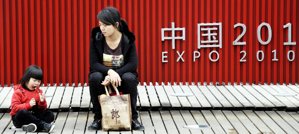 A child (L) eats a candy at the site of the World Expo 2010 in Shanghai on October 29, 2010. Shanghai on October 31 shuts the gates to the World Expo -- a six-month exhibition of culture and technology that saw record attendance, a parade of foreign leaders and a display of China's growing power. AFP PHOTO/Philippe Lopez (Photo credit should read PHILIPPE LOPEZ/AFP/Getty Images)