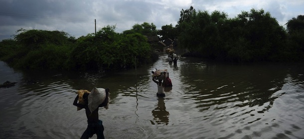 Pakistani villagers carry their belongings through flood water following heavy monsoon rain at Golarchi town in Badin district, about 200 km east of Karachi, on September 13, 2011. The United Nations on September 12 began a drive to feed half a million people affected by torrential rains in Pakistan where a second year of flooding has killed more than 200, officials said. The crisis came just weeks after aid agency Oxfam accused the government of failing to invest in prevention measures after floods last year hit 21 million people and cost the economy 10 billion USD in the country&#8217;s worst natural disaster. AFP PHOTO / ASIF HASSAN (Photo credit should read ASIF HASSAN/AFP/Getty Images)
