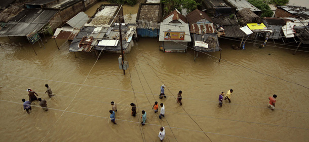 Indian villagers walk along a street after the water level receded near Gop village in Orissa&#8217;s Puri district, about 35 kilometers (22 miles) from Bhubaneswar, India, Tuesday, Sept. 13, 2011. Heavy rains and flooding have killed at least 16 people in eastern India and left nearly 100,000 others homeless, an official said Monday. (AP Photo/Biswaranjan Rout)
