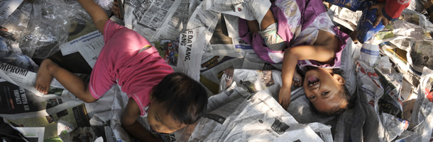 Indonesian children play on newspapers used as prayer mats outside the Al-Azhar mosque following morning prayers celebrating the start of the three-day Eid al-Fitr festival in Jakarta on August 30, 2011. The world's most populated Muslim nation, Indonesia, started Eid-al-Fitr celebrations marking the end of Muslim's holy fasting month of Ramadan. AFP PHOTO / ROMEO GACAD (Photo credit should read ROMEO GACAD/AFP/Getty Images)