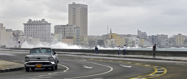 A classic old car drives along the coastline while a giant wave hits the seafront in Havana on November 16, 2008. A cold front that affects Cuba is causing giant waves. AFP PHOTO/STR (Photo credit should read STR/AFP/Getty Images)

