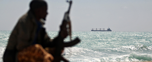 Photo made on January 7, 2010 shows an armed Somali pirate along the coastline while the Greek cargo ship, MV Filitsa, is seen anchored just off the shores of Hobyo town in northeastern Somalia where its being held by pirates. A six-nation east African regional bloc on February 1, 2010 urged Somalia&#8217;s two breakaway regions of Puntland and Somaliland to jointly battle Islamist militia which it said had extended to the areas. AFP PHOTO/ MOHAMED DAHIR (Photo credit should read MOHAMED DAHIR/AFP/Getty Images)
