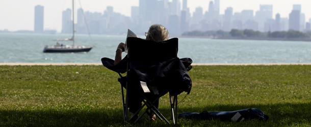 A woman reads a newspaper as she rests during hot weather at Montrose beach on Wednesday, Aug 31, 2011, in Chicago. Final day of August features a return to 90-degree temperatures after 3 consecutive sub-80-degrees days. (AP Photo/Nam Y. Huh)