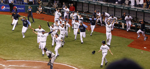 Tampa Bay Rays rush the field after teammate Evan Longoria hit a 12th-inning home run off New York Yankees relief pitcher Scott Proctor during a baseball game early Thursday, Sept. 29, 2011, in St. Petersburg, Fla. With the win, the Rays clinched the AL wild card. (AP Photo/Mike Carlson)
