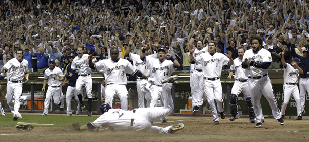 Milwaukee Brewers&#8217; Carlos Gomez (27) is mobbed by teammates as he scored the game-winning run during the 10th inning of Game 5 of baseball&#8217;s National League division series against the Arizona Diamondbacks Friday, Oct. 7, 2011, in Milwaukee. The Brewers won 3-2 to advance to the National League championship series. (AP Photo/David J. Phillip)
