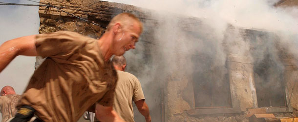 ORGUN-E, AFGHANISTAN &#8211; SEPTEMBER 9: Lt. Carlin Williams of the U.S. 82nd Airborne runs to help fight a fire that broke out September 9, 2002 in the kitchen at the Orgun-e Kalay forward base in Afghanistan. The fire was caused by a leaking propane tank in the kitchen. The building on fire was completely gutted. (Photo by Chris Hondros/Getty Images)
