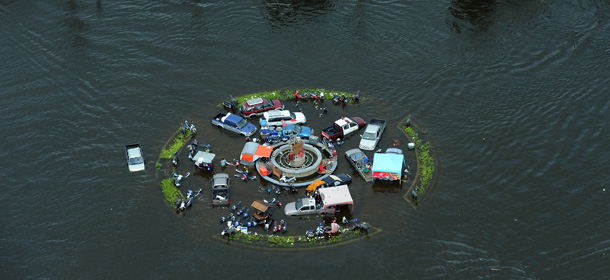 An aerial picture shows partially submerged vehicles stranded in floodwaters at a roundabout in the city of Ayutthaya, north of Bangkok, on October 16, 2011. Flood defences protecting the Thai capital held up on October 16, but the advancing waters that have swamped the inland still threaten to engulf Bangkok in a disaster that has claimed 300 lives. Thailand&#8217;s worst floods in decades have inundated huge swathes of the kingdom, swallowing homes and businesses, shutting down industry, and forcing tens of thousands of people to seek refuge in shelters. AFP PHOTO / Christophe ARCHAMBAULT (Photo credit should read CHRISTOPHE ARCHAMBAULT/AFP/Getty Images)
