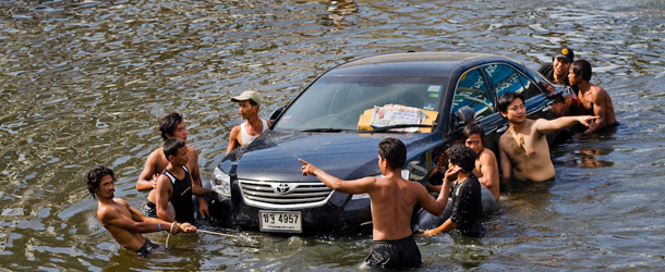 PATHUM THANI, THAILAND &#8211; OCTOBER 22: Thai residents make their way through the flooded streets October 22, 2011 in Pathum Thani on the outskirts of Bangkok, Thailand. Hundreds of factories closed in the central Thai province of Ayutthaya and Nonthaburi as the waters come closer to threaten Bangkok as well. Around 320 people have died in flood-related incidents since late July according to the Department of Disaster Prevention and Mitigation. Thailand is experiencing the worst flooding in 50 years with damages running as high as $6 billion which could increase of the floods swamp Bangkok. (Photo by Daniel Berehulak /Getty Images)
