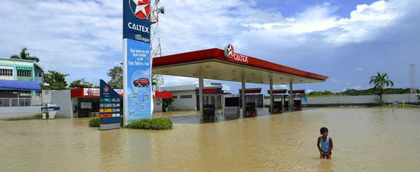A child plays at a flooded gasoline station in a farming town of Calumpit on October 3, 2011, two hours drive north of Manila in Bulacan province, a flat farming region hit particularly hard by the heavy rains of Typhoons Nesat and Nalgae. Authorities were rushing aid to thousands of people marooned in their flooded homes for nearly a week after deadly typhoons, but said the worst appeared over with waters receding. AFP PHOTO / JAY DIRECTO (Photo credit should read JAY DIRECTO/AFP/Getty Images)
