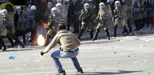 A protester throws a petrol bomb to riot policemen during clashes in Athens on Thursday, Oct. 20, 2011. Clashes have broken out in central Athens between rival groups of demonstrators, amid a second day of mass demonstrations against a new round of austerity measures being debated in parliament. Police fired tear gas and stun grenades outside parliament as several hundred masked youths attacked peaceful demonstrators from a Communist-backed trade union who had tried to isolate the from the rally. (AP Photo)
