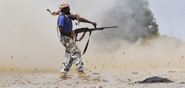 A Libyan revolutionary fighter fires his machinegun while attacking pro-Gadhafi forces inside the Ouagadougou conference center of Sirte, Libya, Friday, Oct. 7, 2011. Rebel forces have besieged Sirte since September 15 but have not managed to penetrate the heart of the city because of fierce resistance from loyalists inside the home town of Libya&#8217;s ousted leader Moammar Gadhafi. (AP Photo/Bela Szandelszky)
