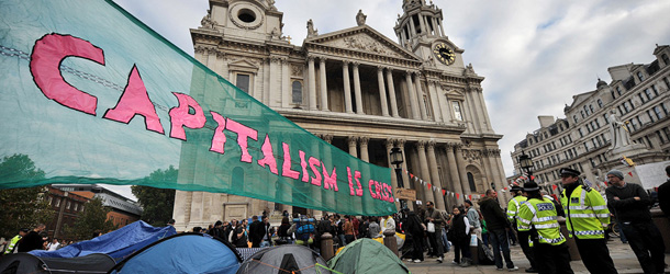 A banner reading &#8216;Capitalism is Crisis&#8217; is displayed in front of St Paul&#8217;s Cathedral in the city of London on October 16, 2011 as part of a global day of protests inspired by the &#8220;Occupy Wall Street&#8221; and &#8220;Indignant&#8221; movements. A large group of demonstrators gathered near the London Stock Exchange to protest against the banks&#8217; handling of the financial crisis. AFP PHOTO/Ben Stansall (Photo credit should read BEN STANSALL/AFP/Getty Images)
