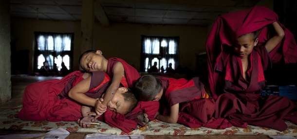 THIMPHU, BHUTAN &#8211; OCTOBER 18: Novice Bhutanese monks Sangey, 6, and Tenzin, 7, and Tandin, 4, and Pembar, 10, rest after hours of prayer at the Dechen Phodrang monastery October 18, 2011 in Thimphu, Bhutan. About 375 monks reside at the government run monastery that also doubles as a child care facility for under privileged and orphaned males. The monks average about 10 hours of study a day waking up at 5:00am. Mahayana Buddhism is the state religion, although in the southern areas many citizens openly practice Hinduism. Monks join the monastery at six to nine years of age and according to tradition many families will send one son into the monk hood. They learn to read chhokey, the language of the ancient sacred texts, as well as Dzongkha and English. (Photo by Paula Bronstein/Getty Images)
