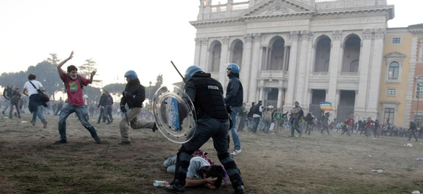 A police officer subdues a protester in front of the St. John in Lateran basilica during clashes in Rome, Saturday, Oct. 15, 2011. Italian police fired tear gas and water cannons as protesters in Rome turned a demonstration against corporate greed into a riot Saturday, smashing shop and bank windows, torching cars and hurling bottles. The protest in the Italian capital was part of the Occupy Wall Street demonstrations against capitalism and austerity measures that went global Saturday, leading to dozens of marches and protests worldwide. (AP Photo/Gregorio Borgia)
