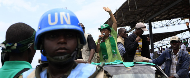 A United Nations soldier stands guard as Liberian President Ellen Johnson Sirleaf waves to supporters during a visit to the Lynch Street area on the final day of campaigning ahead of Tuesday&#8217;s presidential elections, in Monrovia, Liberia Sunday, Oct. 9, 2011. Africa&#8217;s first democratically elected female president, who was honored this week with a Nobel Peace Prize, will face stiff competition at Liberia&#8217;s presidential polls Tuesday against a fiery opposition candidate and his soccer-star running mate.(AP Photo/Rebecca Blackwell)
