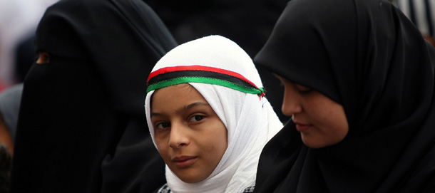 A Libyan girl wearing a headband with the colours of the rebellion&#8217;s flag attends the weekly Muslim Friday prayers in the rebel stronghold of Bengazhi on April 22, 2011. Libyan insurgents bogged down in their bid to oust Moamer Kadhafi hailed a US decision to deploy armed drones over Libya. AFP PHOTO/MARWAN NAAMANI (Photo credit should read MARWAN NAAMANI/AFP/Getty Images)
