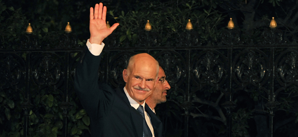 Greek Prime Minister George Papandreou greets reporters while arriving for his meeting with the Greek President in Athens on November 9, 2011. Papandreou pledged his support for his yet-to-be named successor on November 9 as he formally stepped down as leader of the debt-wracked country. AFP PHOTO / LOUISA GOULIAMAKI (Photo credit should read LOUISA GOULIAMAKI/AFP/Getty Images)
