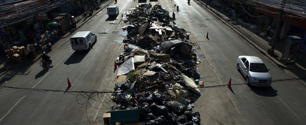 Vehicles drive past a garbage pile in the center of the main road in Bangkok on November 18, 2011. More than 562 people have been killed across the country in Thailand&#8217;s worst floods in half a century, which have inundated parts of the capital. AFP PHOTO/ SAEED KHAN (Photo credit should read SAEED KHAN/AFP/Getty Images)
